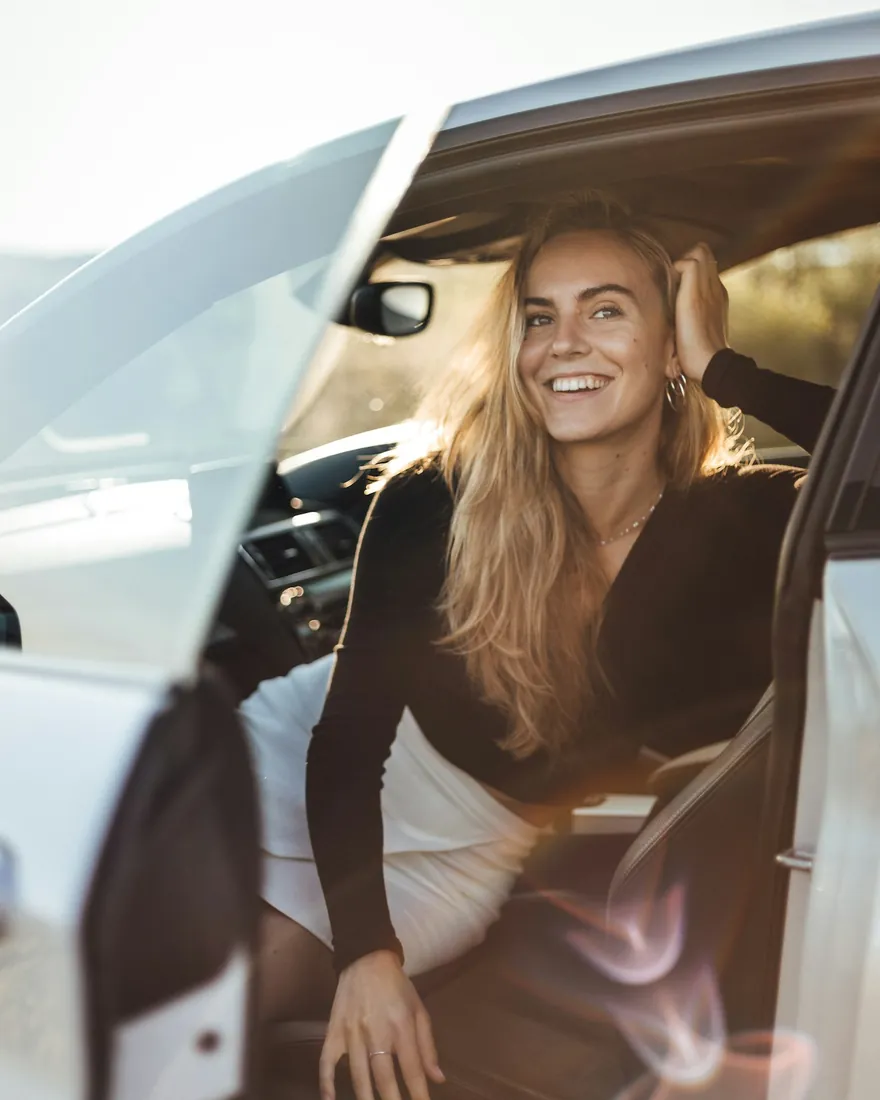 Cliente sorrindo dentro do carro, com o financiamento resolvido